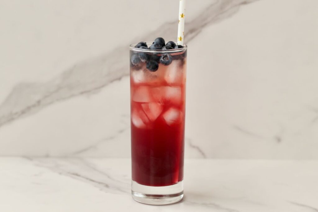 DIY electrolyte drink with blueberries and straw