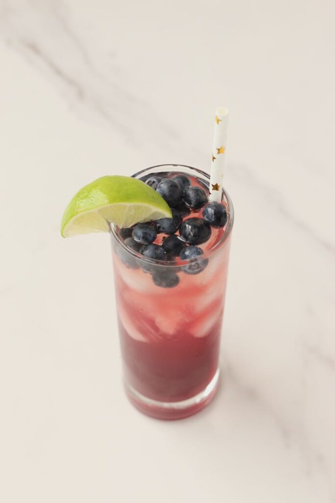 DIY electrolyte drink with blueberries, lime wedge and star straw