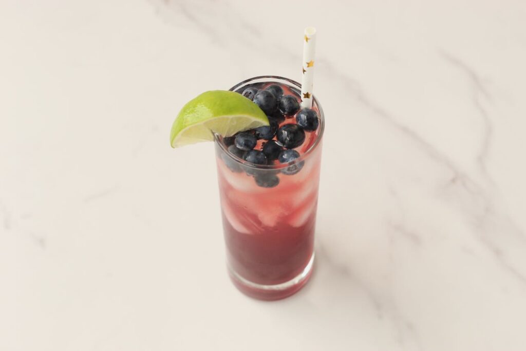 DIY electrolyte cooler with blueberries, lime wedge and star straw