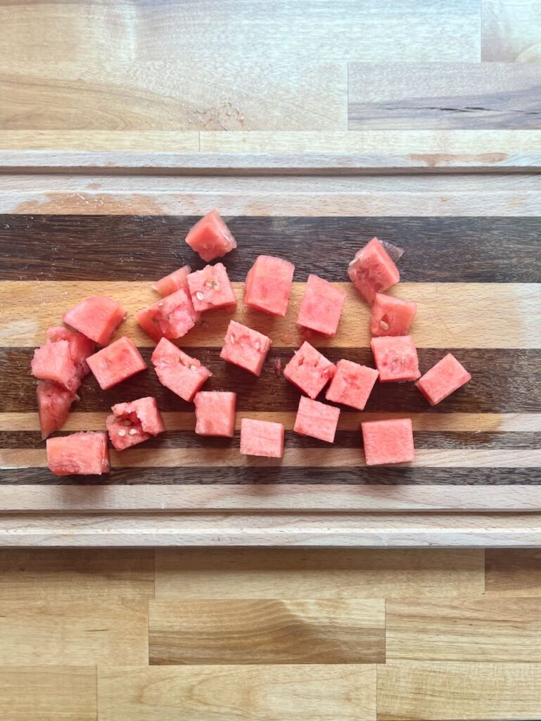 Watermelon cubes on cutting board