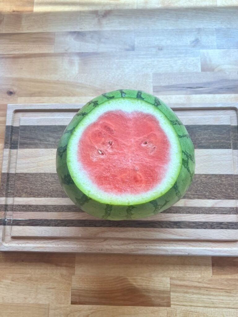 Watermelon standing on flat end on cutting board