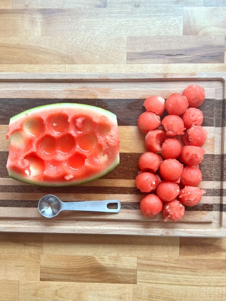 Watermelon balls on cutting board with 1/2 tablespoon 
