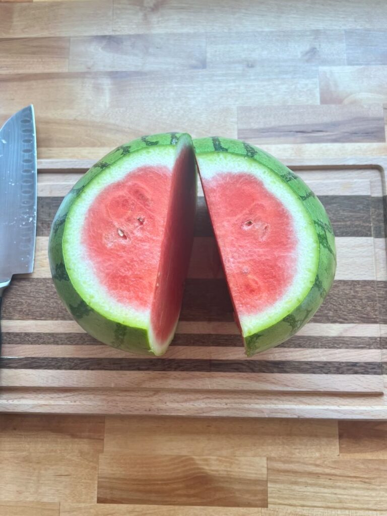 Watermelon cut in half on cutting board