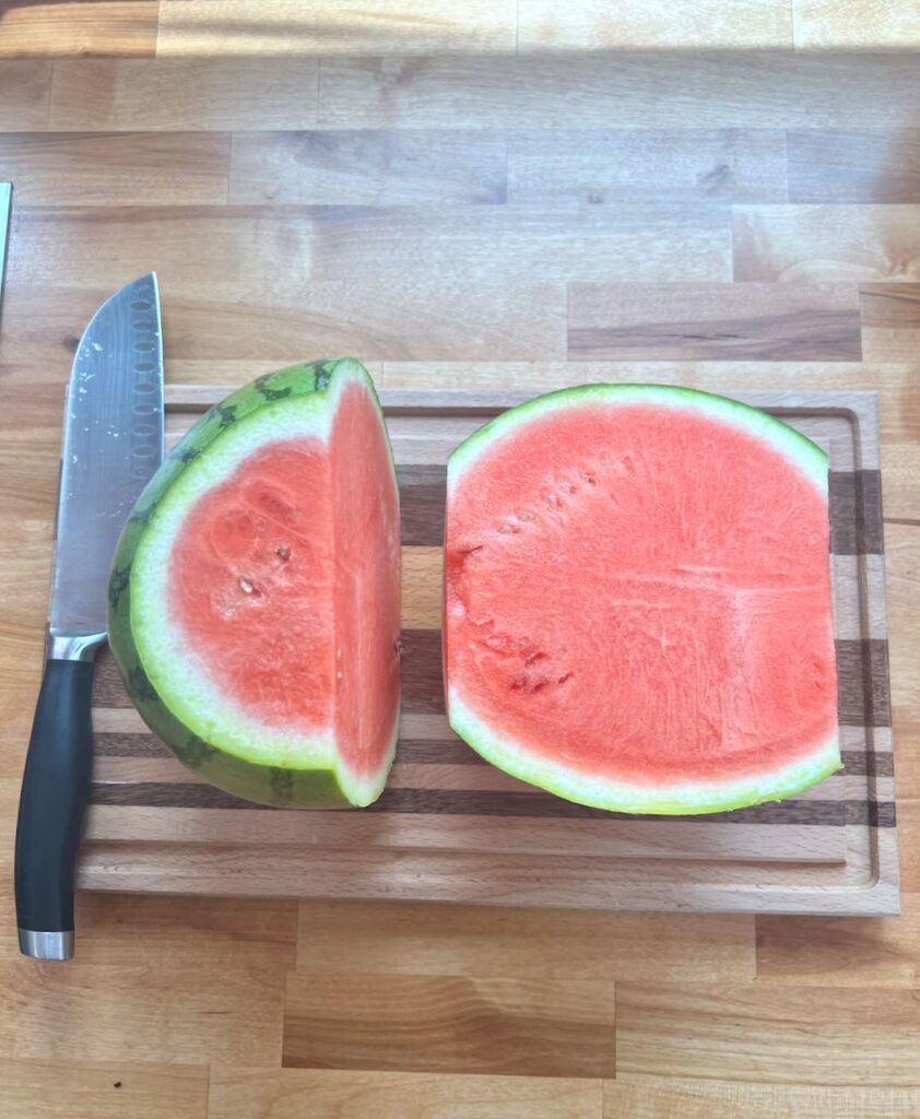 Watermelon cut in half with ends cut off on cutting board