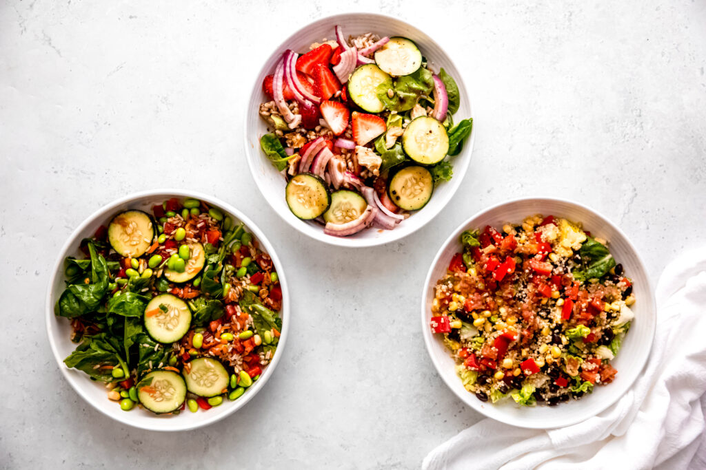3 different salad flavor combos in white bowls