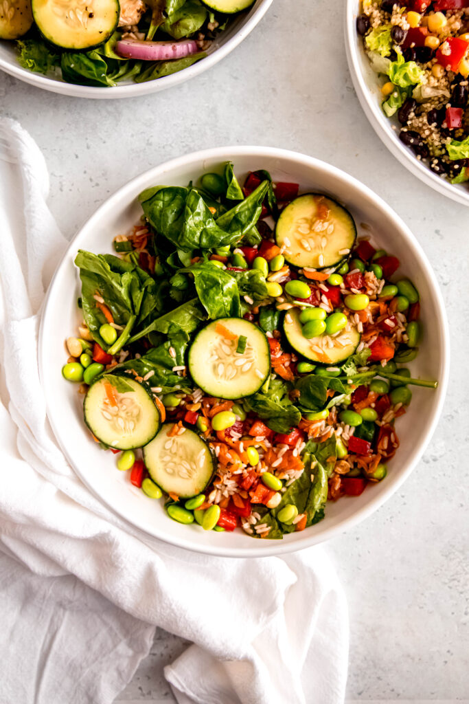 Asian-inspired salad in white bowl with white napkin