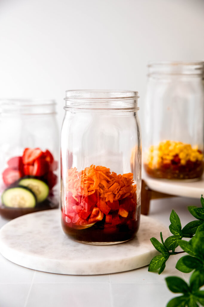 Mason jar with veggies on top of dressing