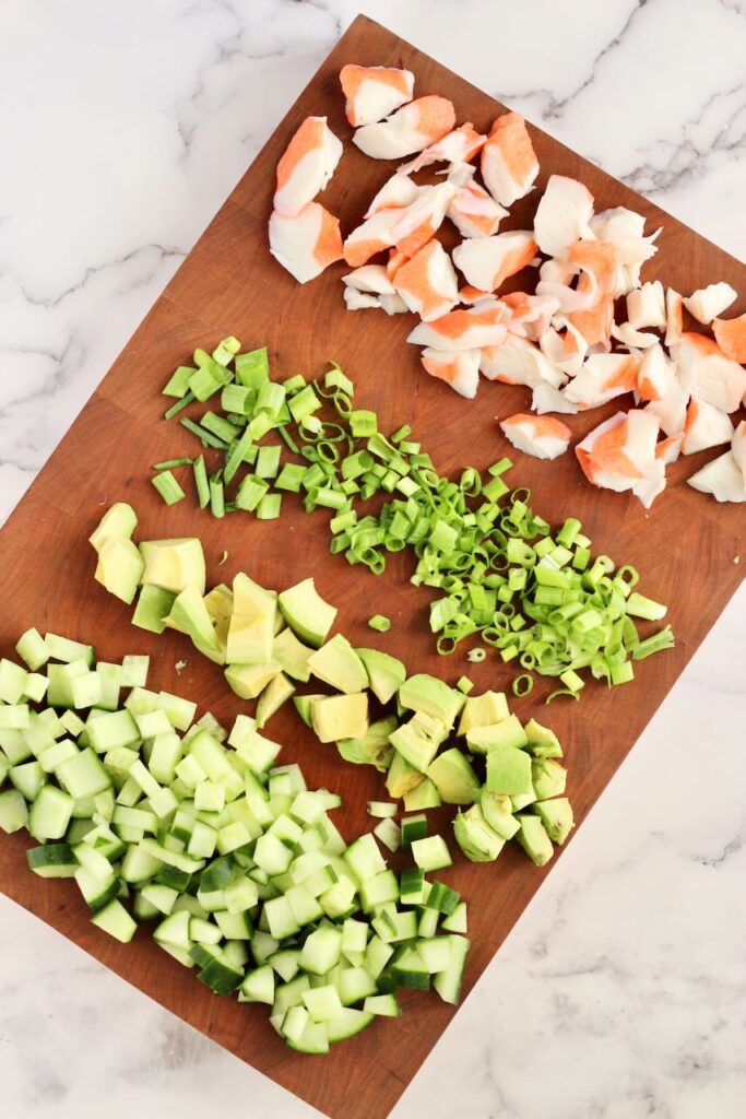 Ingredients on wood cutting board to make California-Style Sushi Bowl \