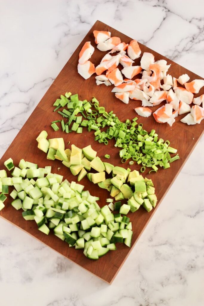 Ingredients on wood cutting board to make California-Style Sushi Bowl 