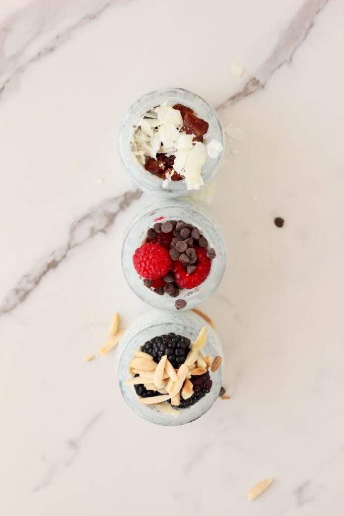 Overhead view of 3 types of chia pudding in jars with different toppings