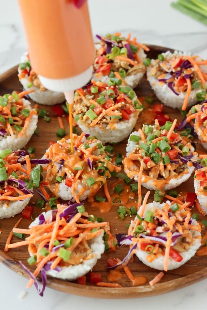 Korean BBQ Chicken Rice Cups drizzling gochujang mayo on top