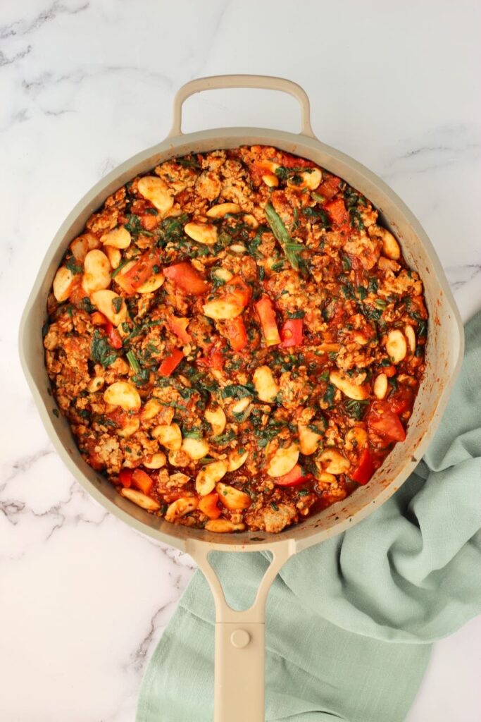 Pizza beans in skillet and kitchen towel in background