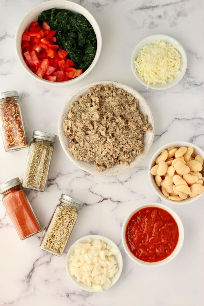 Ingredients to make pizza beans in white bowls