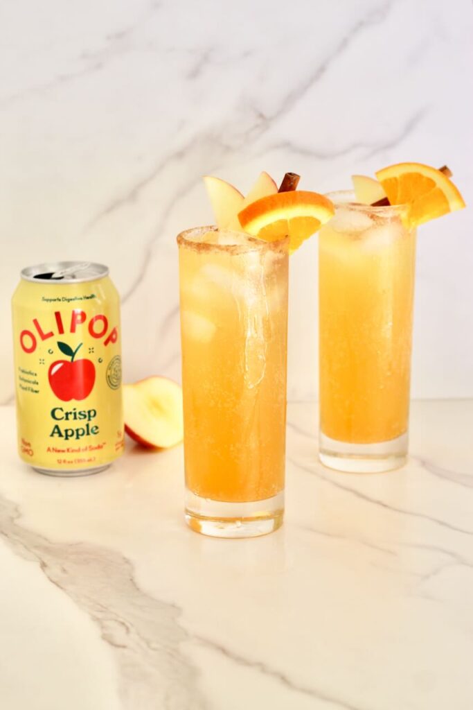 Two apple cider mocktails with olipop can 