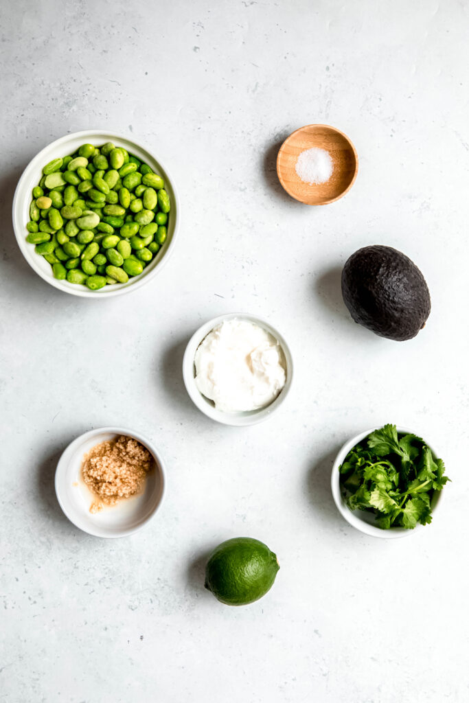 A group of bowls of food filled with guac ingredients
