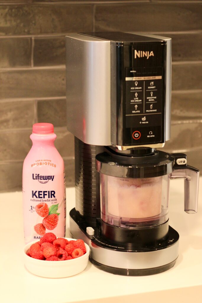 Ninja creami spinning pint, with raspberry Lifeway kefir bottle next to it