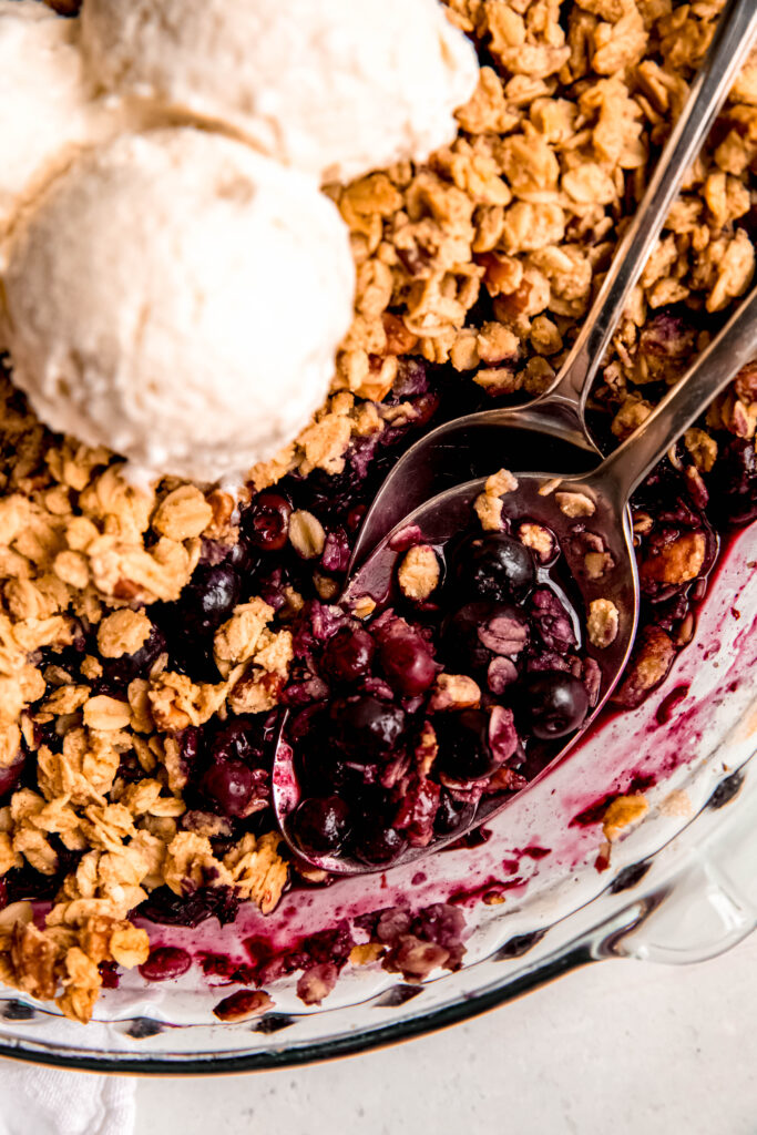 Close up of Customizable Fruit Crisp with spoons with blueberries on it.
