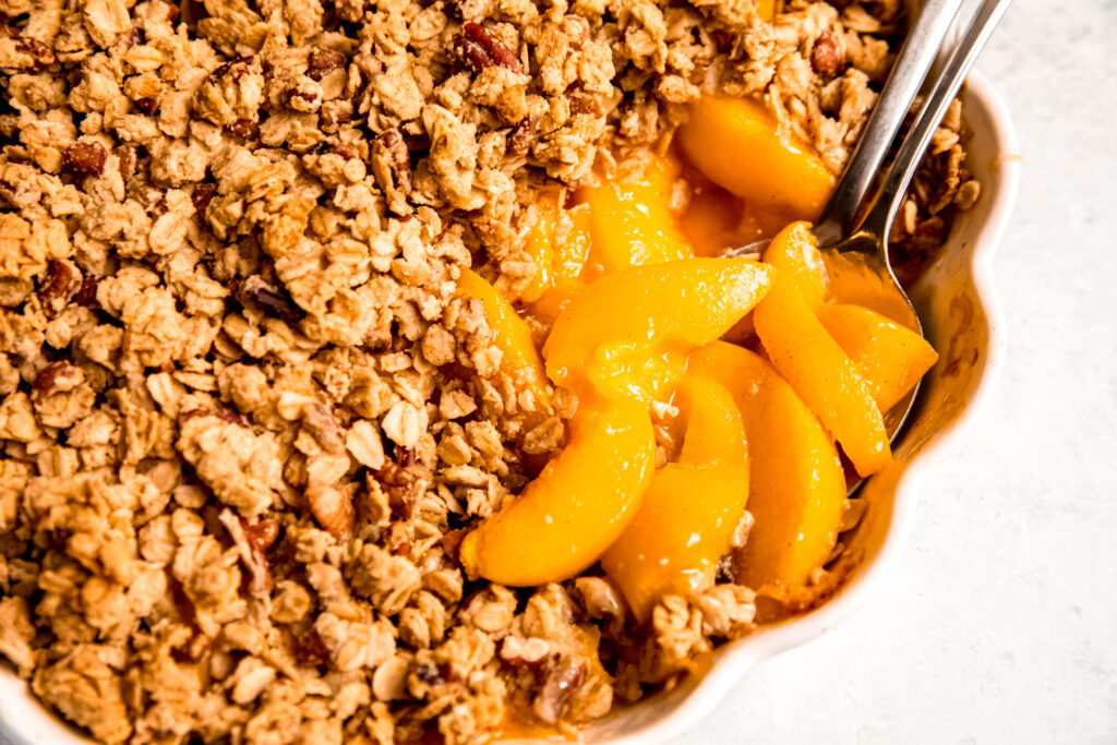 Customizable Fruit Crisp with spoons with peaches on it.
