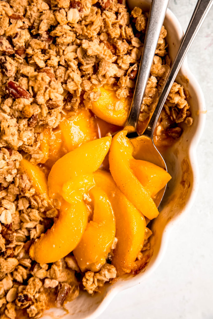 Customizable Fruit Crisp with spoons with peaches on it.
