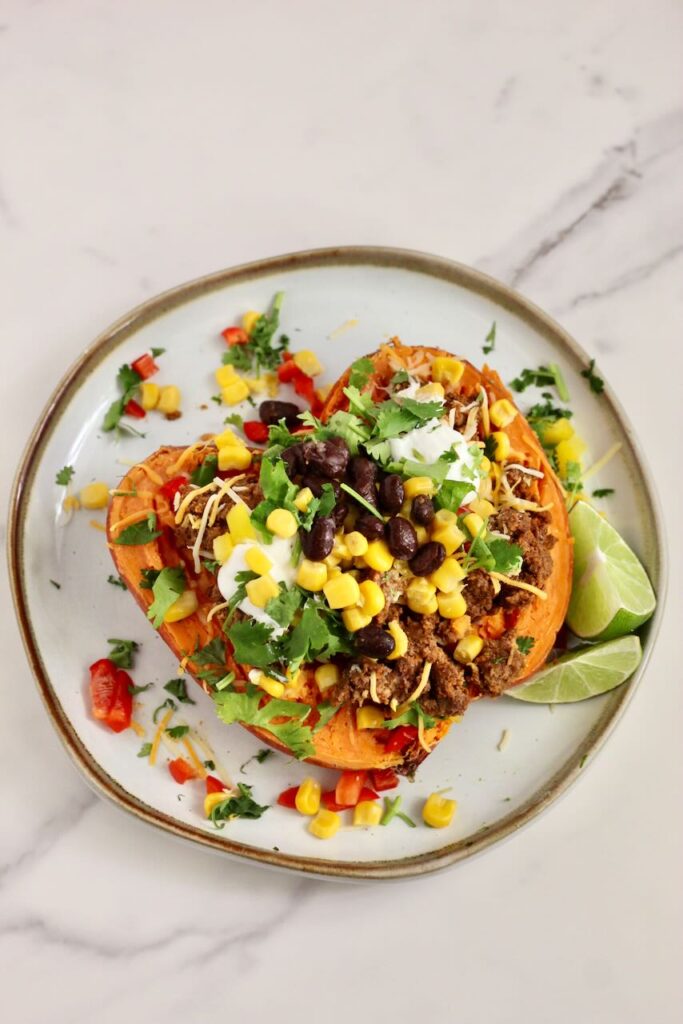 Stuffed Sweet Potato Taco Bar: baked potato with toppings of choice on plate.