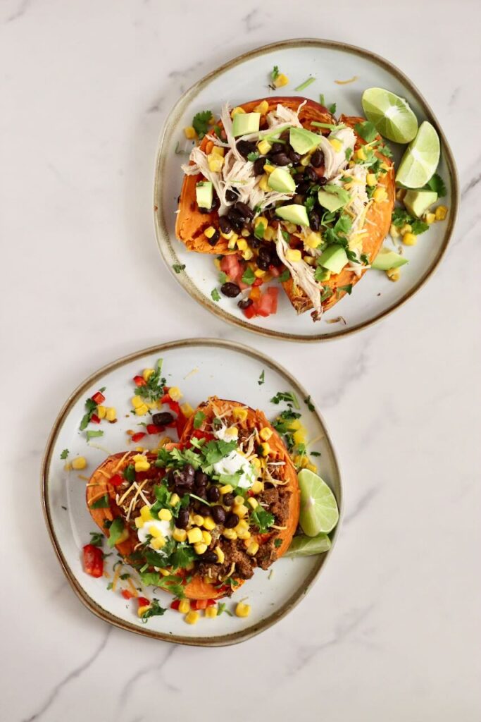 Stuffed Sweet Potato Taco Bar: two plates of potatoes with toppings of choice and lime wedges. 