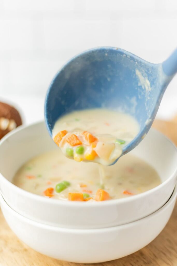 Creamy soup with vegetables being served