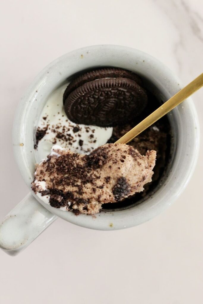 gold spoon taking scoop out of oreo protein mug cake