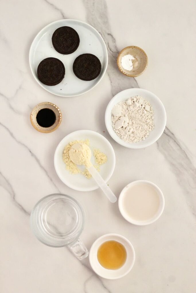 Ingredients for oreo protein mug cake in separate white bowls