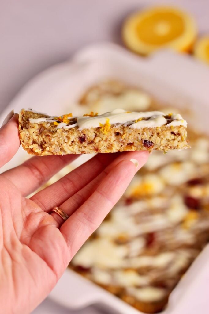Hand showing Cranberry Orange Energy Bars from the side view