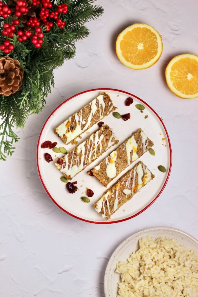 Cranberry Orange Energy Bars on plate with brown rice and orange slices on side
