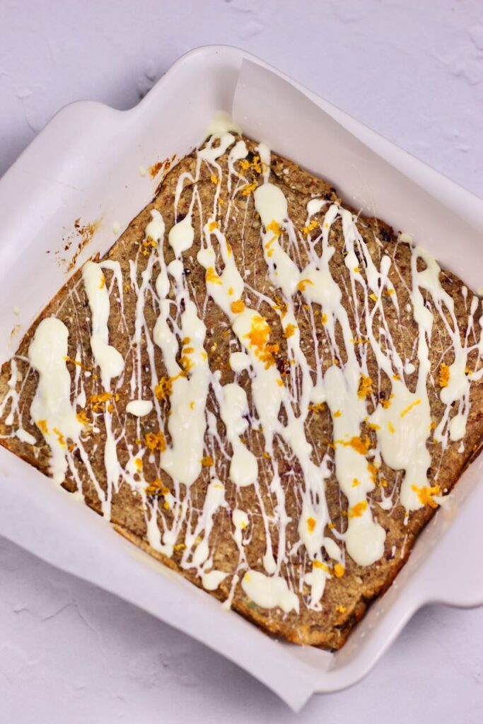 Baked Cranberry Orange Energy Bars with white chocolate drizzle and orange zest added