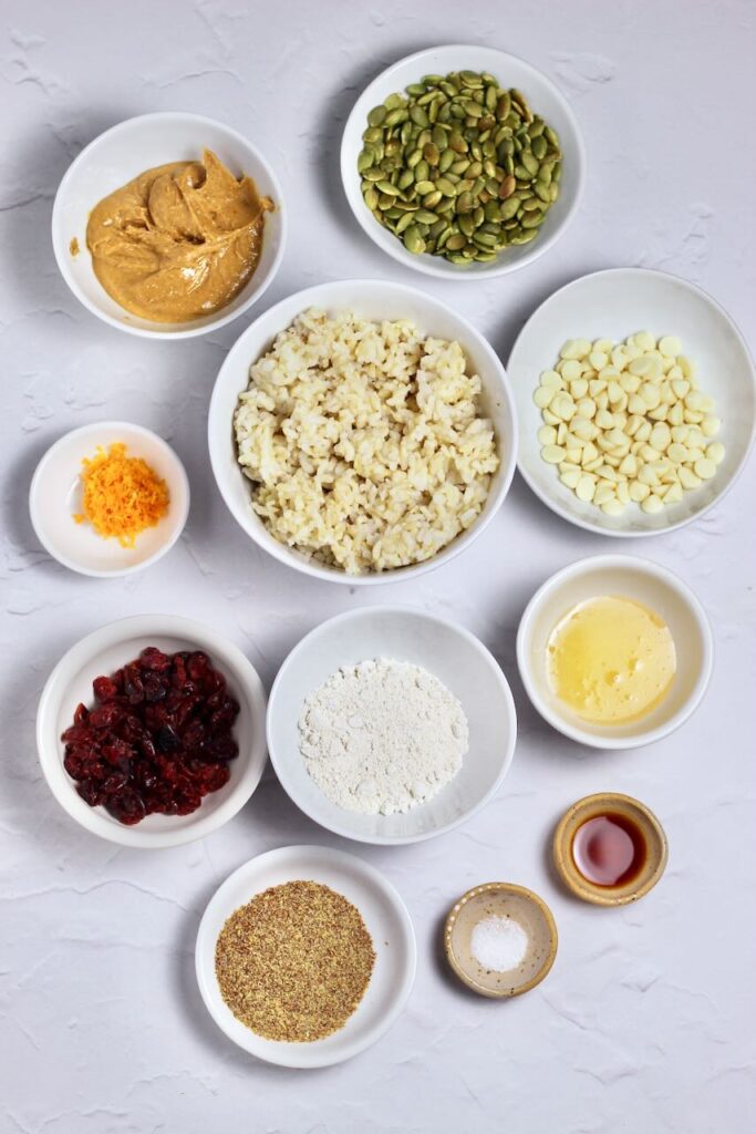 Ingredients for Cranberry Orange Energy Bars in separate white bowls