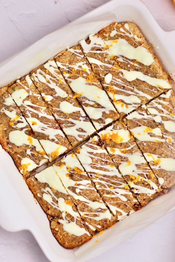Cranberry Orange Energy Bars with white chocolate drizzle and orange zest