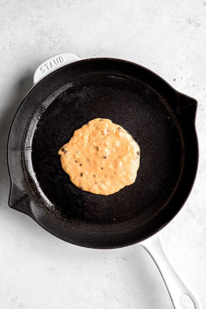 Pancake batter cooking on cast iron pan