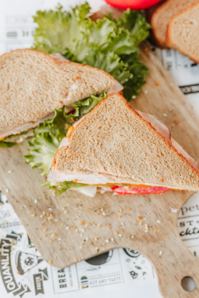 Final healthy sandwich cut in half on wood cutting board