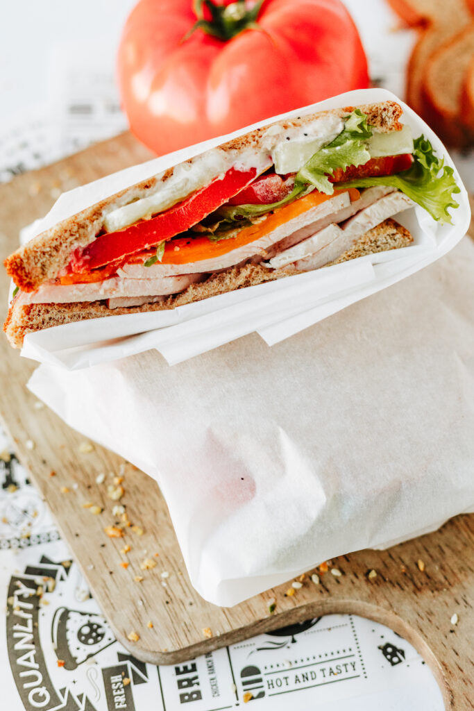 Sandwich wrapped in parchment paper cut in half