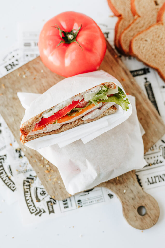 Healthy sandwich wrapped in parchment paper cut in half