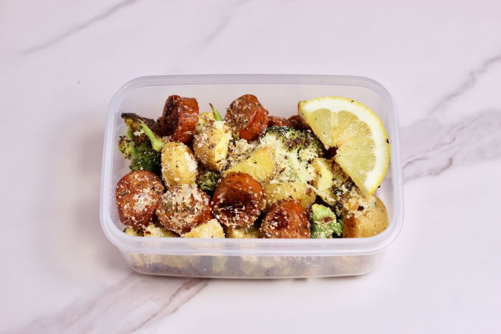 Sheet pan sausage and veggies in meal prep container