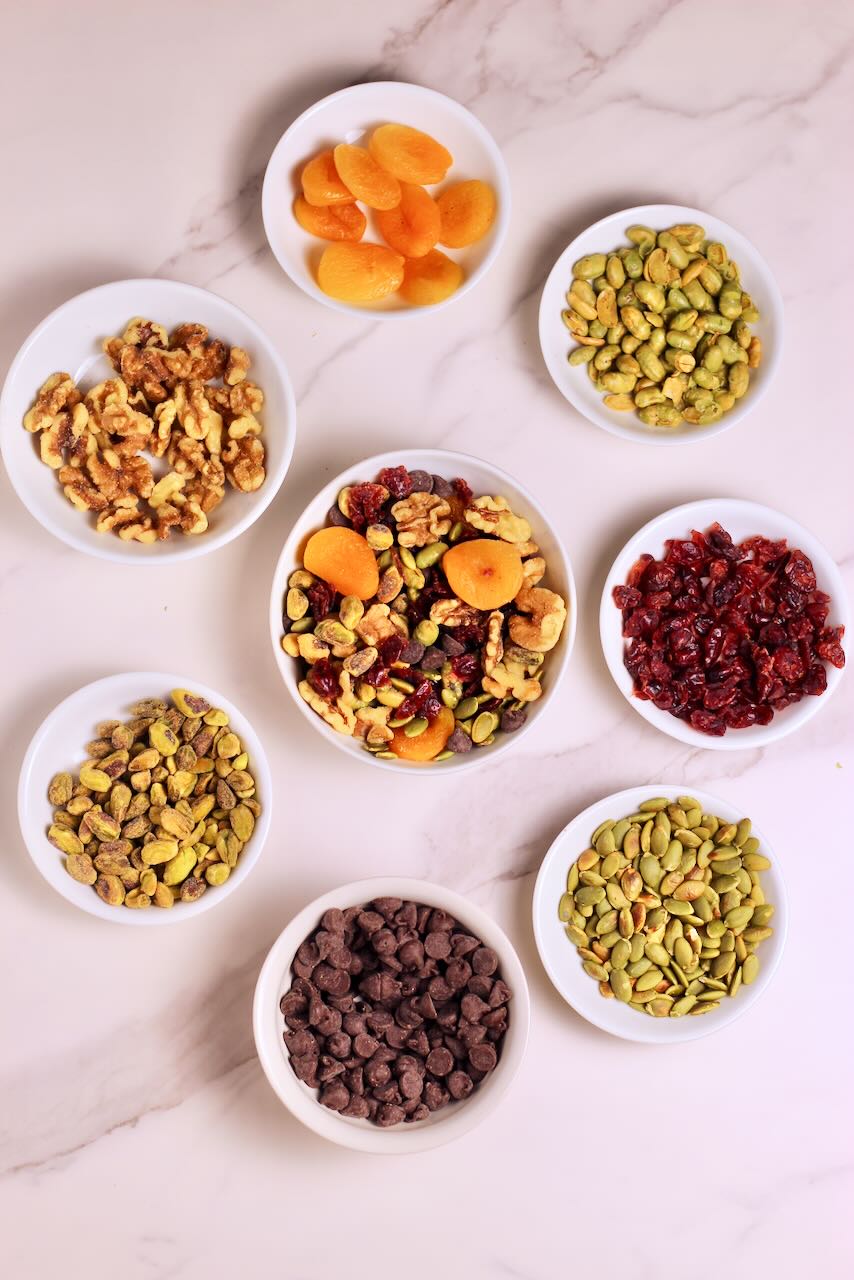 Homemade Trail Mix with nuts, fried fruit, and chocolate chips in white bowls