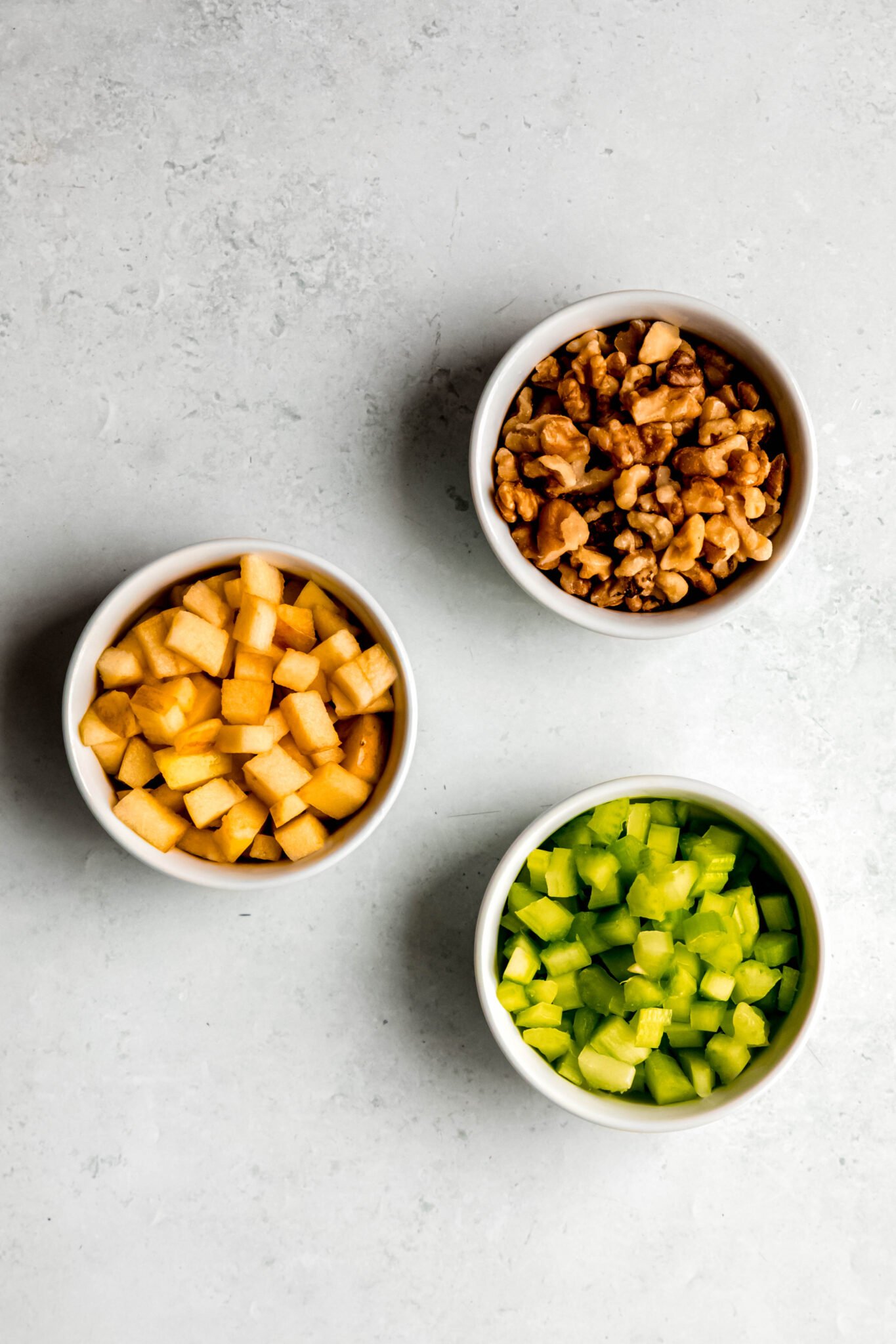 Crunchy add-ins of choice in bowls: apple, celery, walnuts