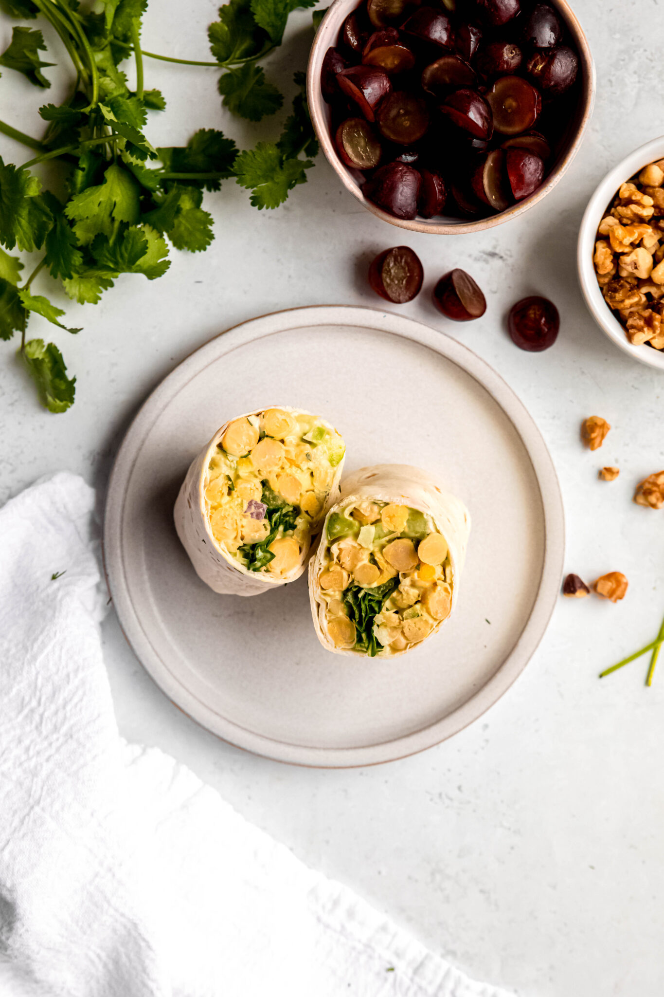 Chickpea salad mixture wrapped in tortilla on plate
