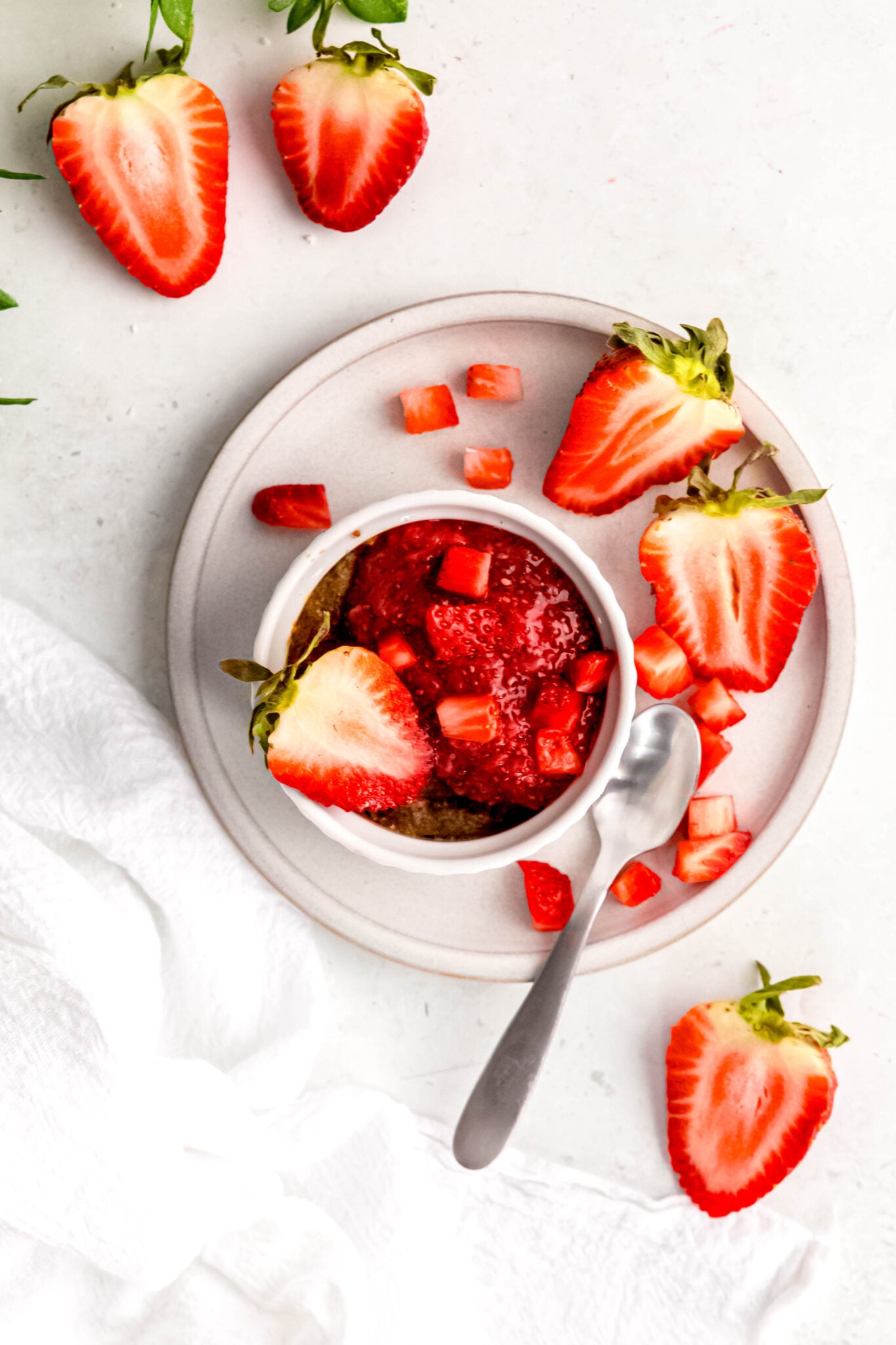 Strawberry Baked Oats with spoon and extra strawberries on side
