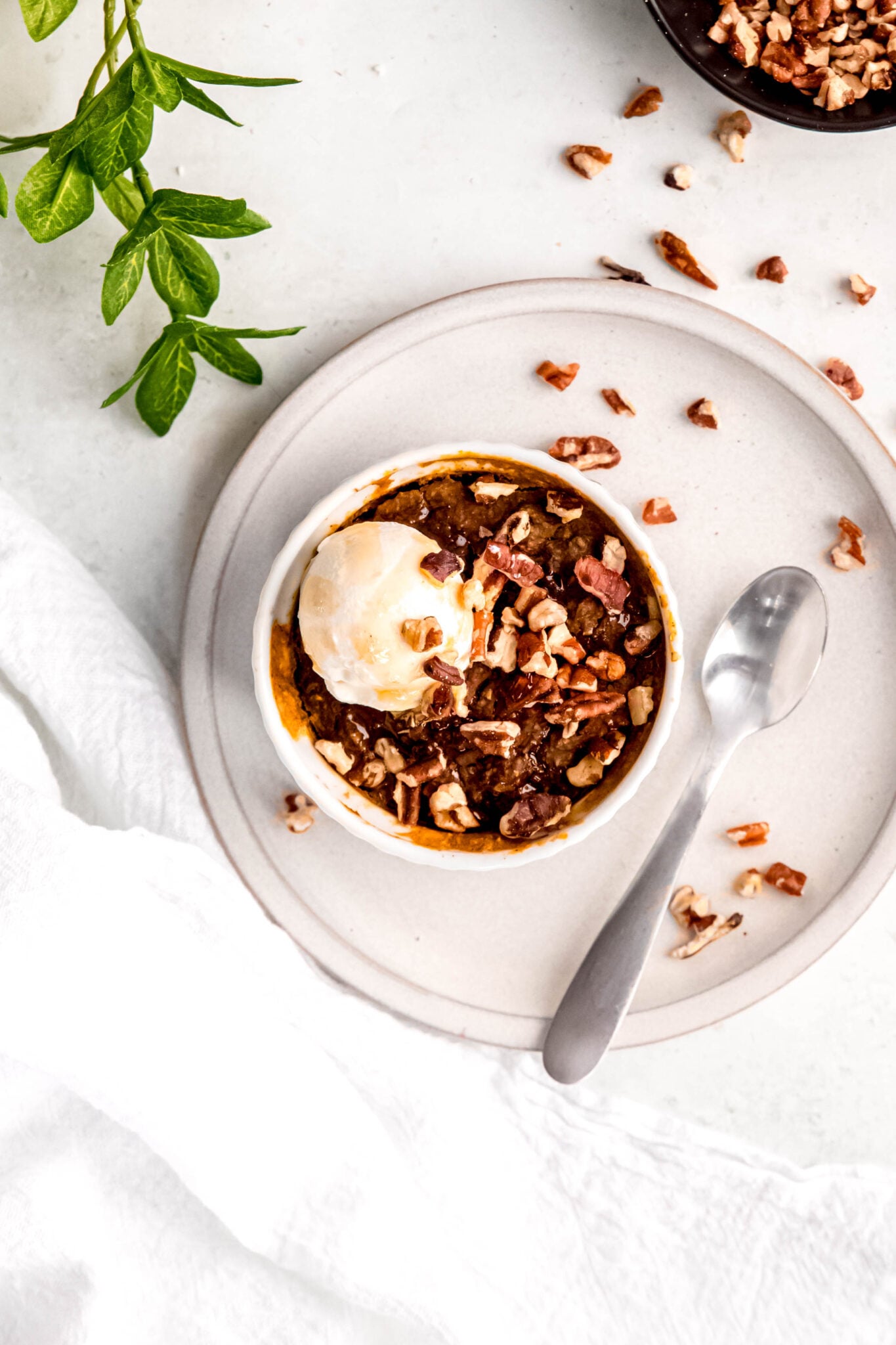 Pumpkin baked oats in white ramekin and spoon on side