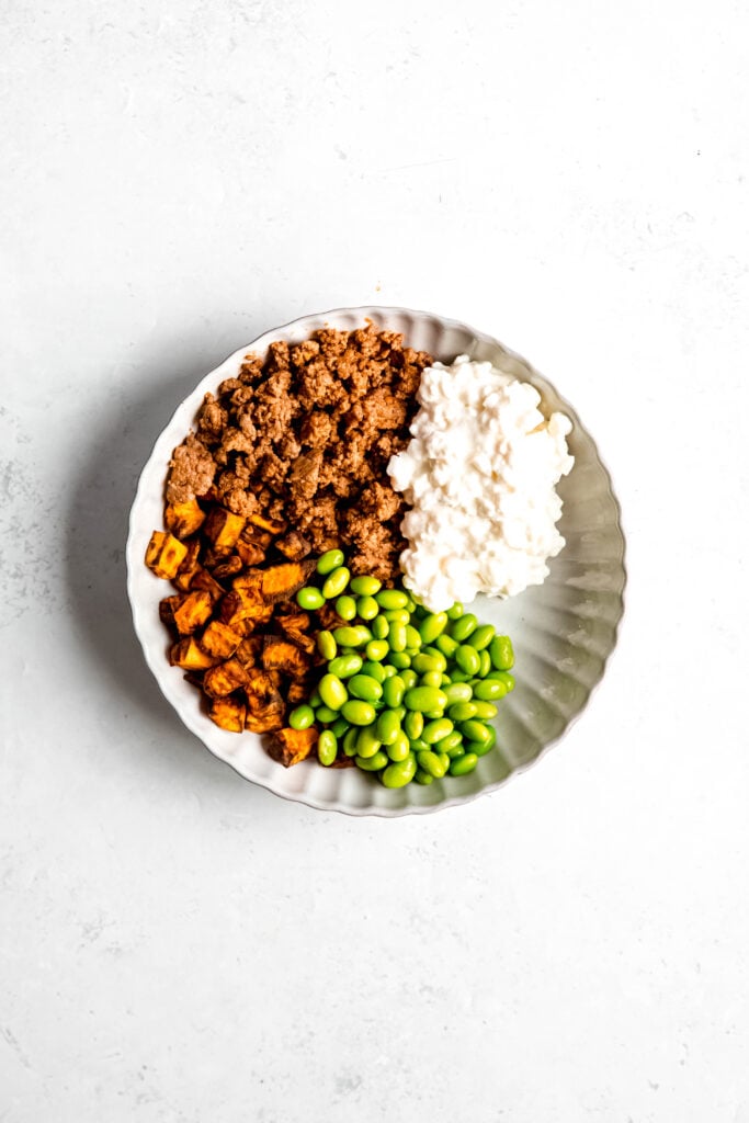 Ground beef, sweet potato, rice, and edamame on white plate