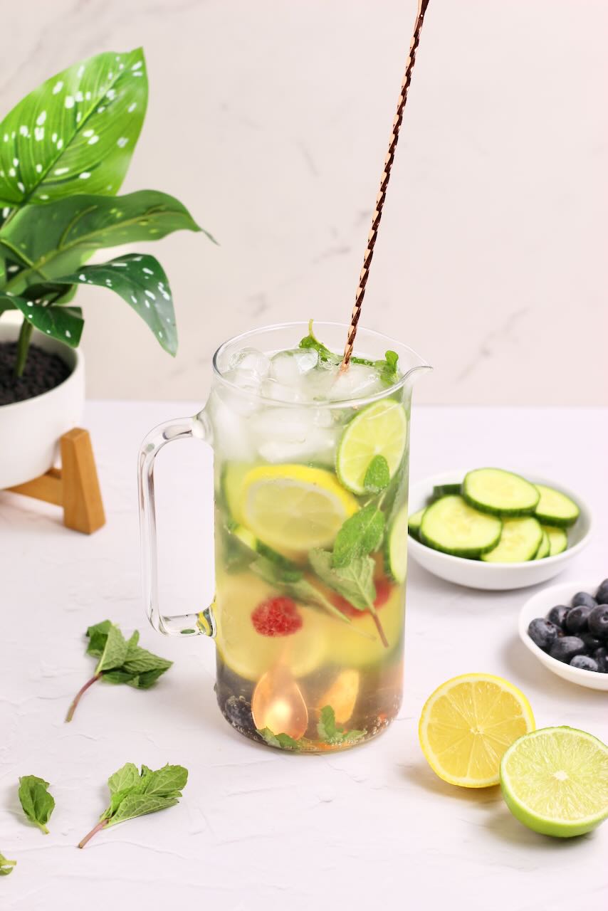 Infused water with lemons, limes, cucumbers, and blueberries with gold spoon