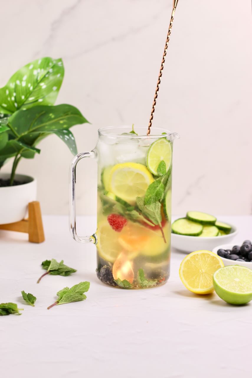 Infused water with lemons, limes, cucumbers, and blueberries with spoon