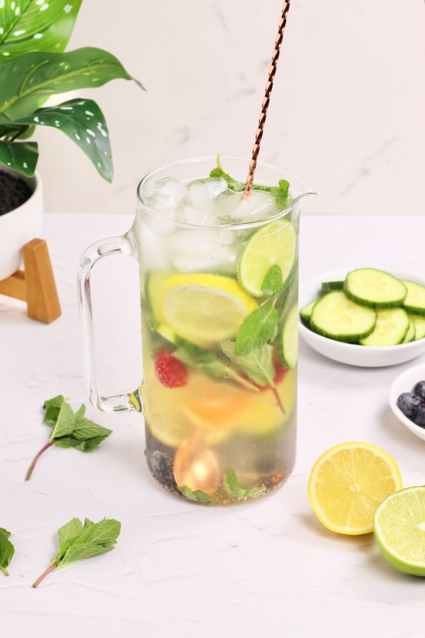 Infused water with lemons, limes, cucumbers, and blueberries with spoon