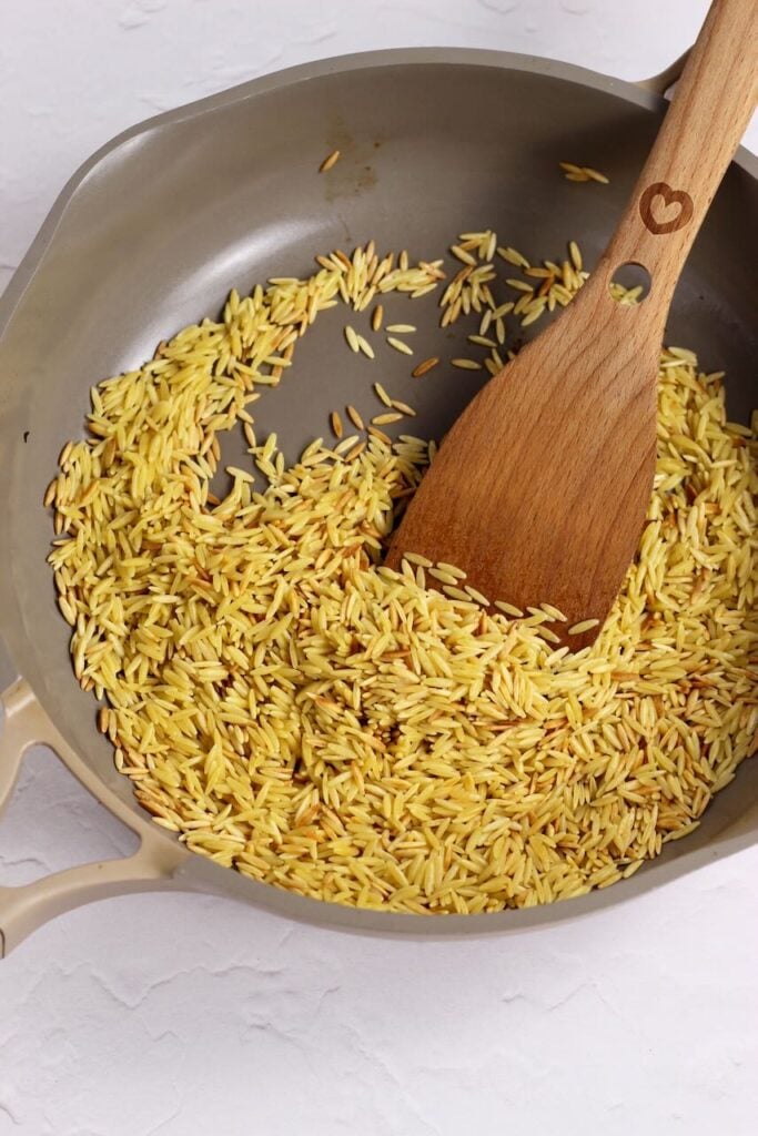Orzo in skillet toasting