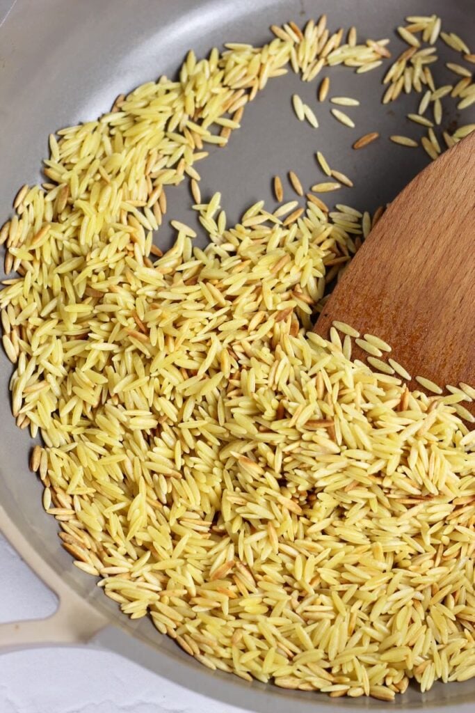 Orzo in skillet toasting