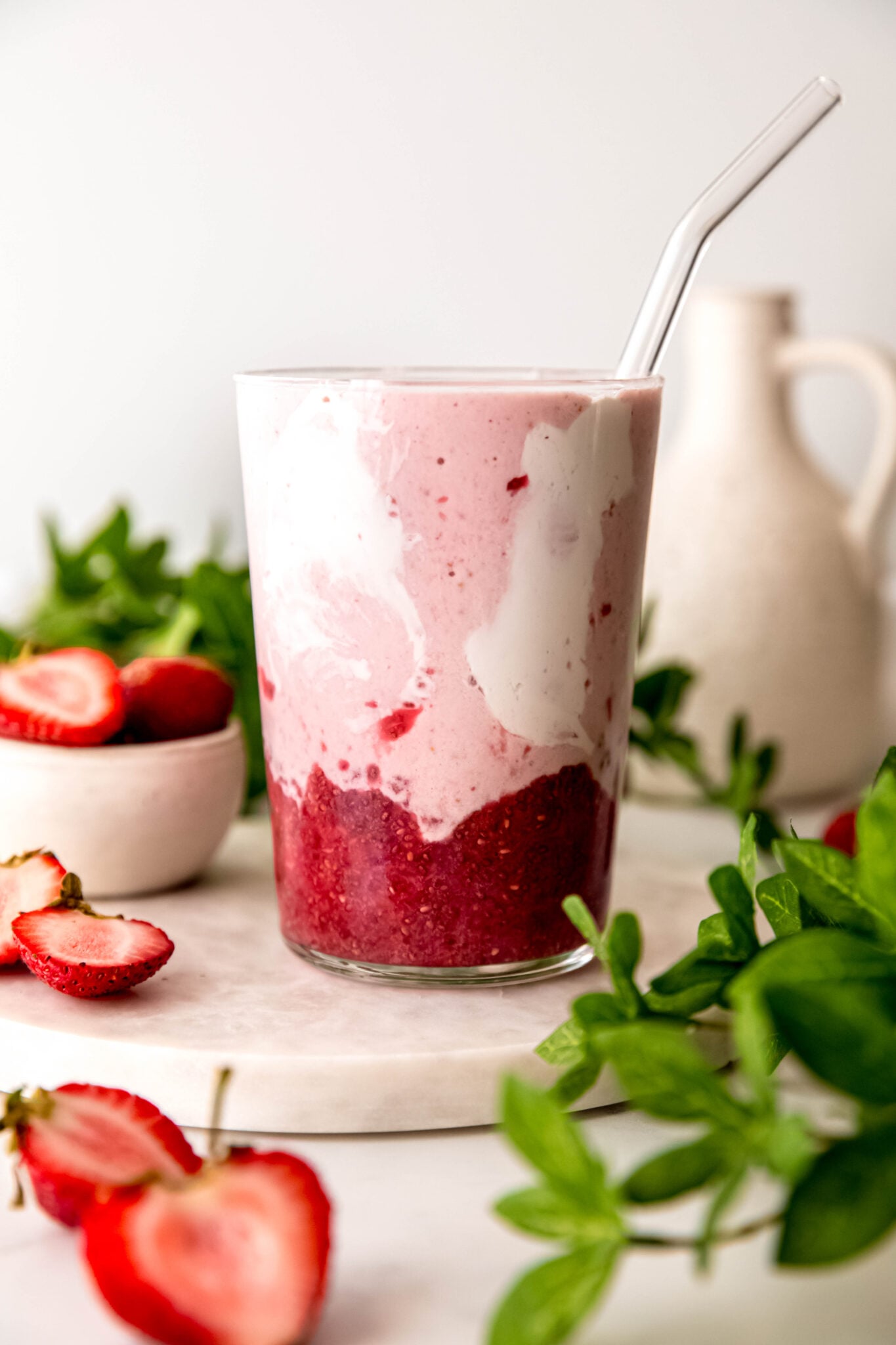 Strawberry smoothie in glass with glass straw